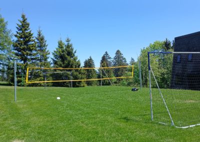 Terrain avec les buts de football et le filet de volley